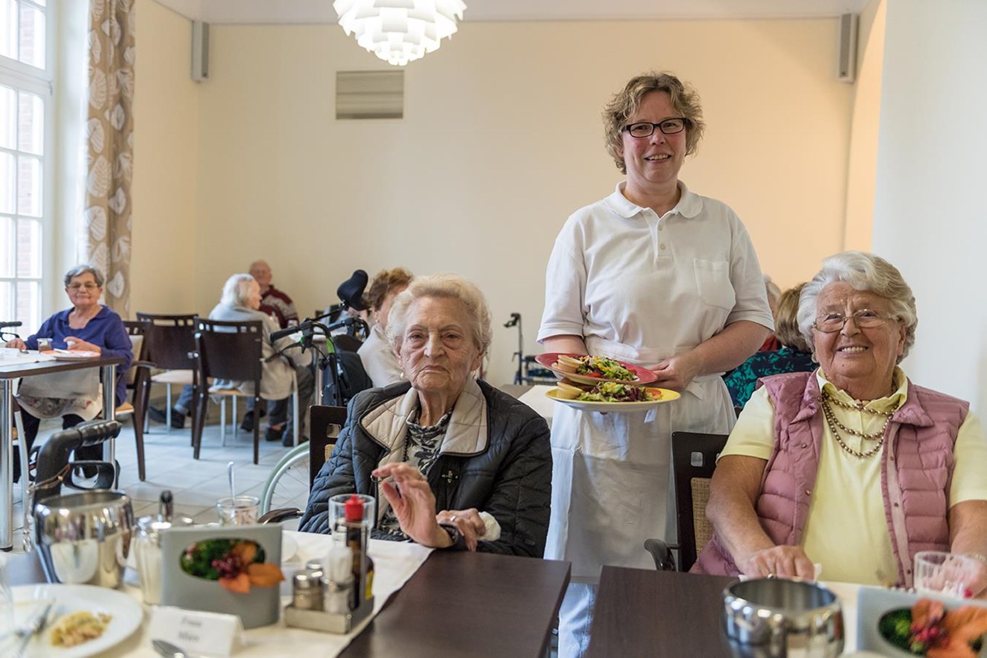 Angestellte gibt Essen aus im Pflegeheim